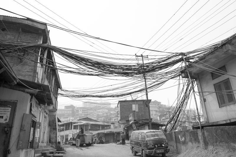 Water cables bundled together and made to hang untidily over and between buildings in Kohima, Nagaland, in the absence of any supporting infrastructure